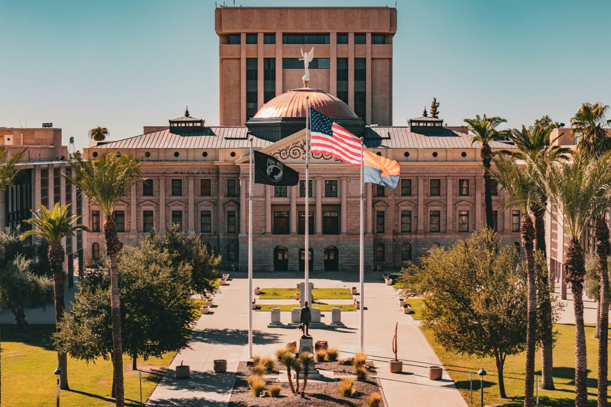 A building with a small plaza and flags on poles